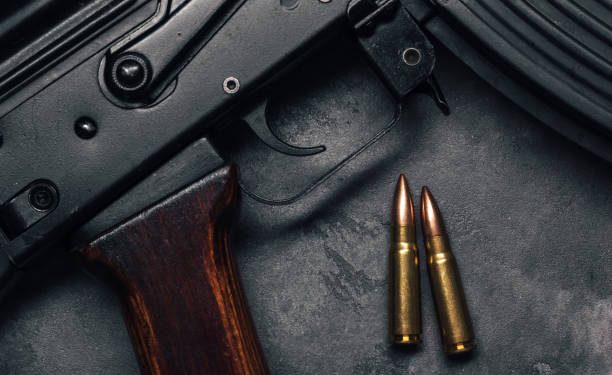 Two bullets and Kalashnikov assault rifle on gray concrete background, top view. Cartridge 7.62 caliber for ak 47 closeup
COURTESY PHOTO