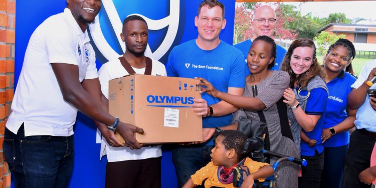 Tich Makonese, the Stanbic Bank Head of Insurance handing over the part of assortment  to the Gem Foundation team