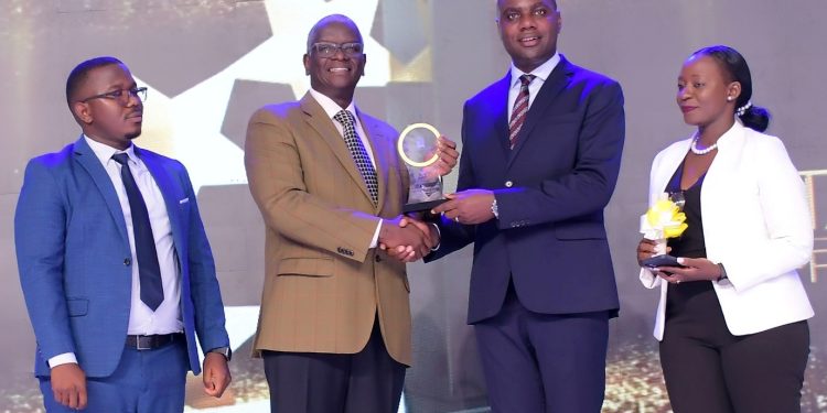 Uganda Breweries Managing Director Andrew Kilonzo (L) receives an award from Henry Musasizi Minister of State General Duties (R) during the Tax Payers Award Ceremony at Uganda Revenue Authority Headquarters