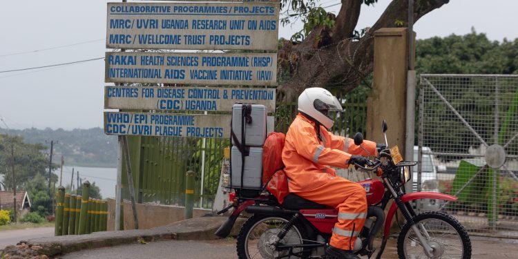 A rider arrives at the Uganda Virus Research Institute laboratory in Entebbe to deliver samples from the environmental surveillance team in Kampala.