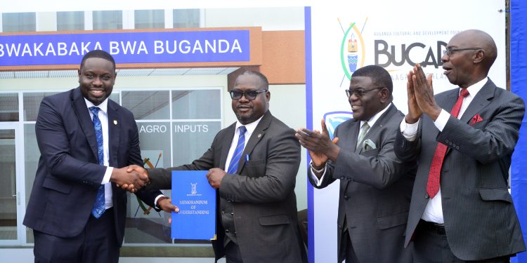 Stanbic Bank Executive Director and Head Corporate Investment Banking (CIB) Paul Muganwa holding the MoU with the Buganda Kingdom leadership lead by Owek. Twaha Kaawaase the 1st Deputy Prime Minister.