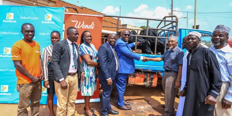 Martin Lukyamuzi (C), the Regional Head of Distribution for Greater Kampala, Mufti Muhammad Kadala (3rd R) representing the leadership of Masjid Swaleh, Bombo, some of the representatives from PostBank Uganda, and Swaleh Masjid, Bombo Mosque during a photo moment where PostBank Uganda shared Eid Al-Adha joy with the Muslim community in Bombo today 28th May 2025 and those across different regions through their branches in Arua, Mbale, and Fort Portal.