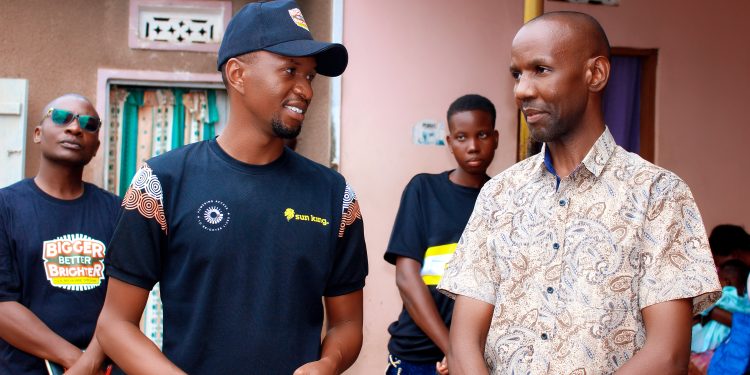 Brian Mugabe the Brand Activations Associate at Sun King Uganda briefs one of the directors of Mutima medical clinic during a visit to the facility
