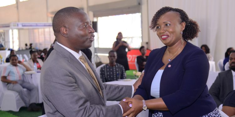 Minister David Bahati (left) chats with Irene Mutyaba Kabiri, the Corporate Banking Director at Absa Bank Uganda during the UMA 2nd Financial Symposium.
