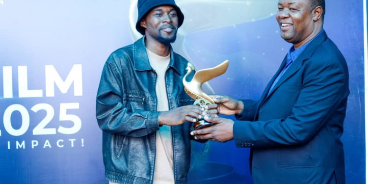 Douglas Byaruhanga (L) recieving an accolade from MultiChoice Uganda Managing Director, Hassan Saleh.