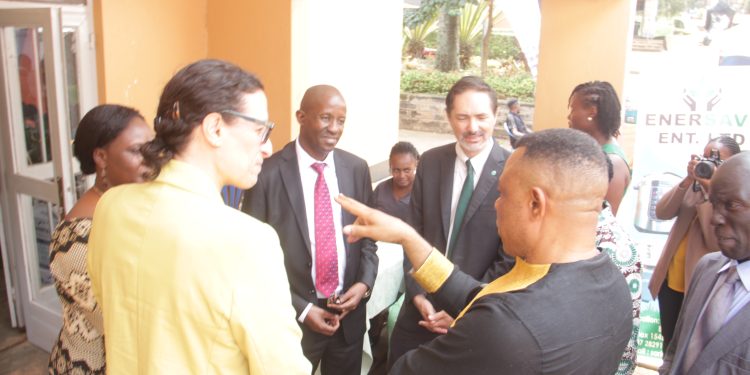 MUBS-principal-Moses-Muhwezi-in-red-tie-looks-on-as-GGGI-officials-engage-in-a-light-conversation-