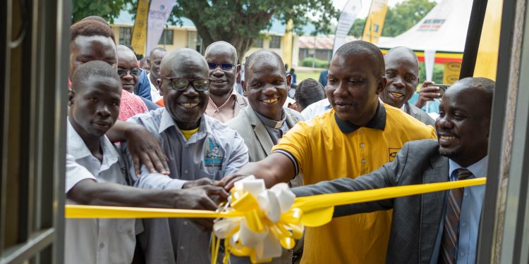 Philip Odoi, MTN’s Commercial Head for Northern Uganda (2nd R), alongside Edward Otim, Regional Director of Sense Uganda (far right), Ayikobua David, school board member (3rd R), school management, and students, cut the ribbon to officially inaugurate the new computer lab at Mvara Secondary School on August 1, 2025