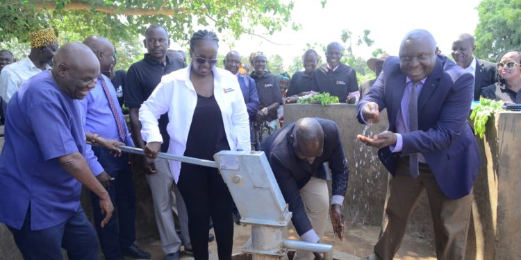 Sheila Sabune, the Corporate Relations Director and Hon.Okasai Opolot operate the borehole as Jimmy Biyomotho , Ministry of Water and Environment Regional Manager (in necktie) washes his hands