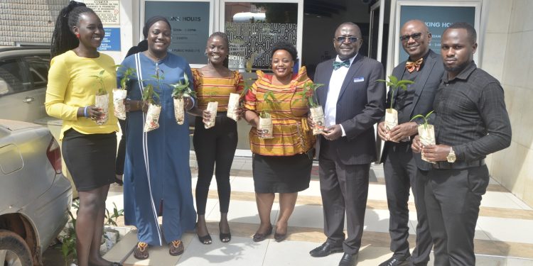 Acting EXIM bank Deputy CEO- Anthony Mariiro(3rd right) with some of the clients and staff during the handover of fruits at the banks headquarters in Kampala.