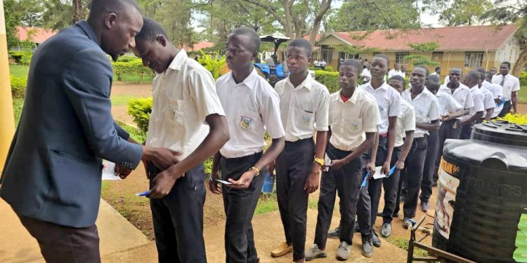 Senior four candidates checked before entering the examination room to ensure that no unauthorized materials were brought in, recently. Courtesy photo.