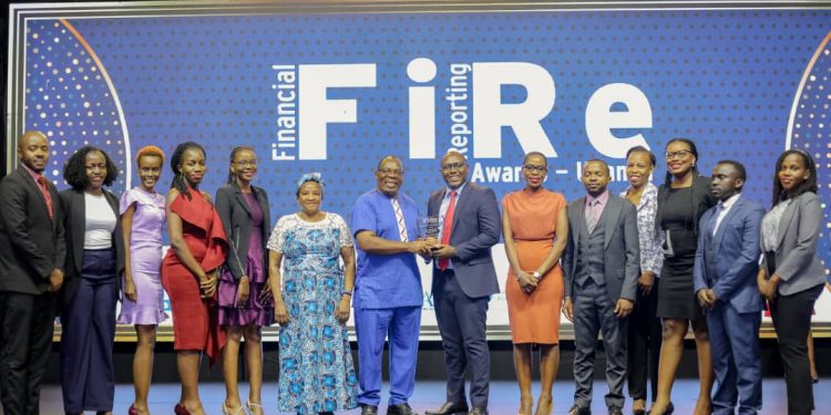 Peter Ssenyange (C), the Chief Financial Officer at Pearl Bank, receiving the Banking Services General Banking Award from John Bosco Ntangaare(7th L), Consultant at the World Bank and ICPAU's former Director of Education. Looking on are staff from Pearl Bank (formerly PostBank Uganda) and other guests.