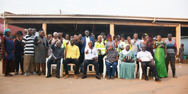 Ian Gumisiriza (in yellow) in group photo with market vendors.