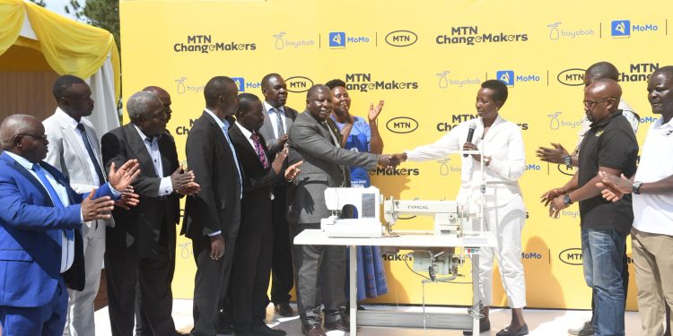Allen-KaginaTrustee-at-MTN-Foundation-and-MTN-Uganda-staff-hands-over-tailoring-machines-and-fabrics-to-Migeera-Women-Centre-of-Influence-in-Nakasongola-District-on-March-24