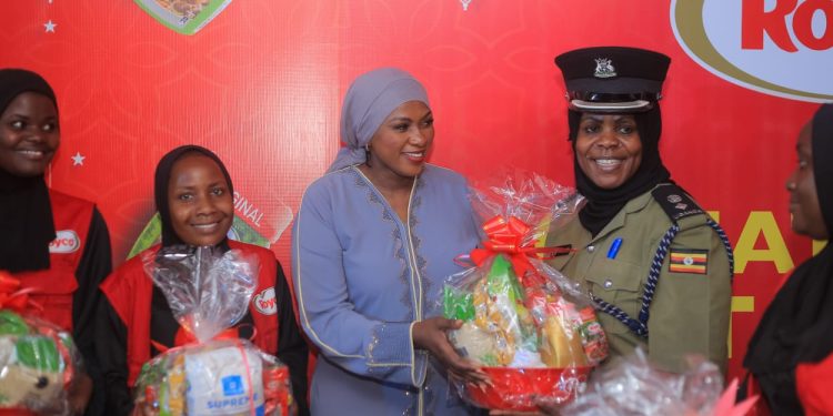 Nandawula Grace, Unilever Uganda Marketing manager while handing over food items to a police officer