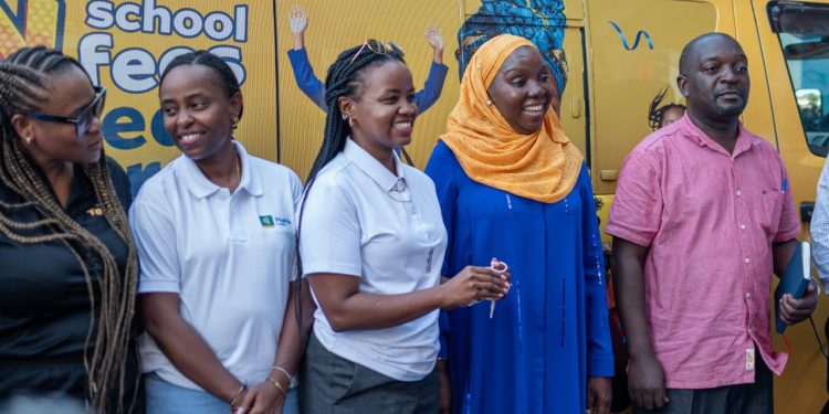 Nandawula Fatumah Batenda, Principal and Director of Lucky Kids Academy, receives the school van keys from Jemima Kariuki, Chief Product Officer at MTN Mobile Money Uganda, at the handover event in Bweyogerere.