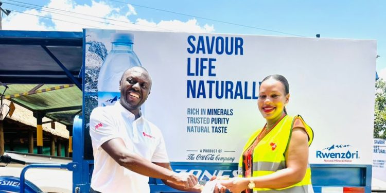 Ellis Muhimbise, Sales Director at CCBU handing over Tuk-Tuks