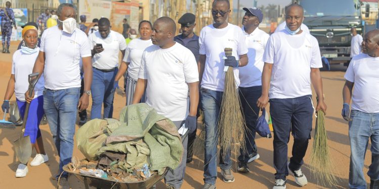 State Minister, David Bahat while Pushing the wheelbarrow during the clean up exercise in industrial area.